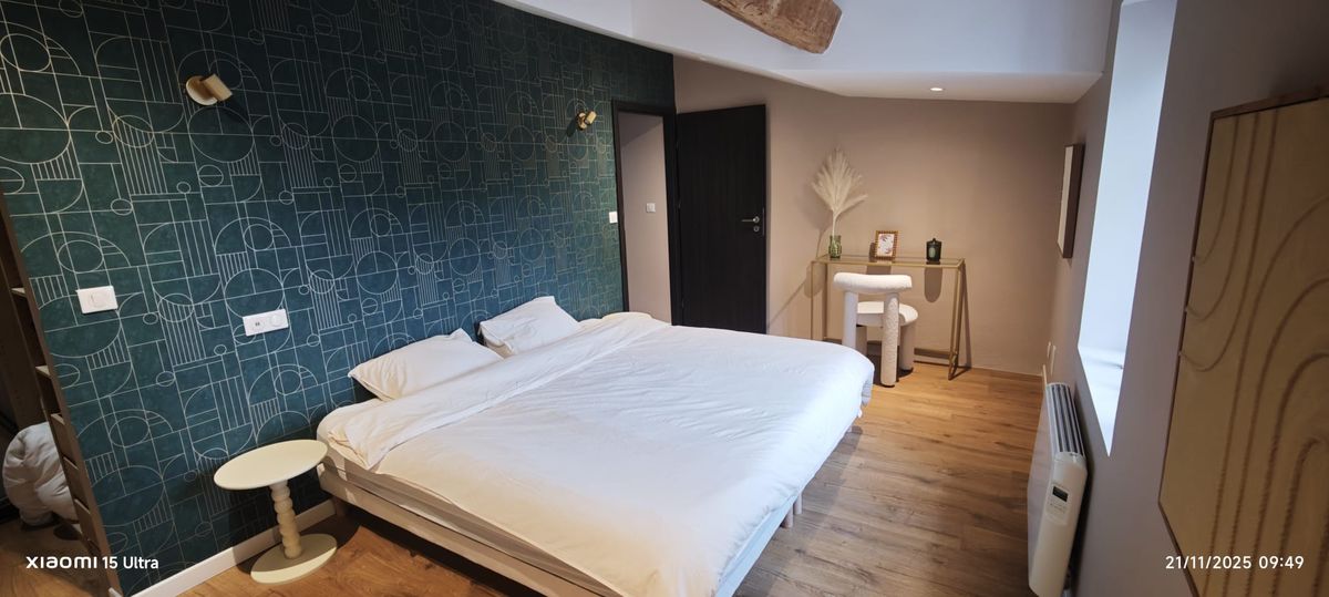 Bedroom — graphic teal wallpaper & exposed beam