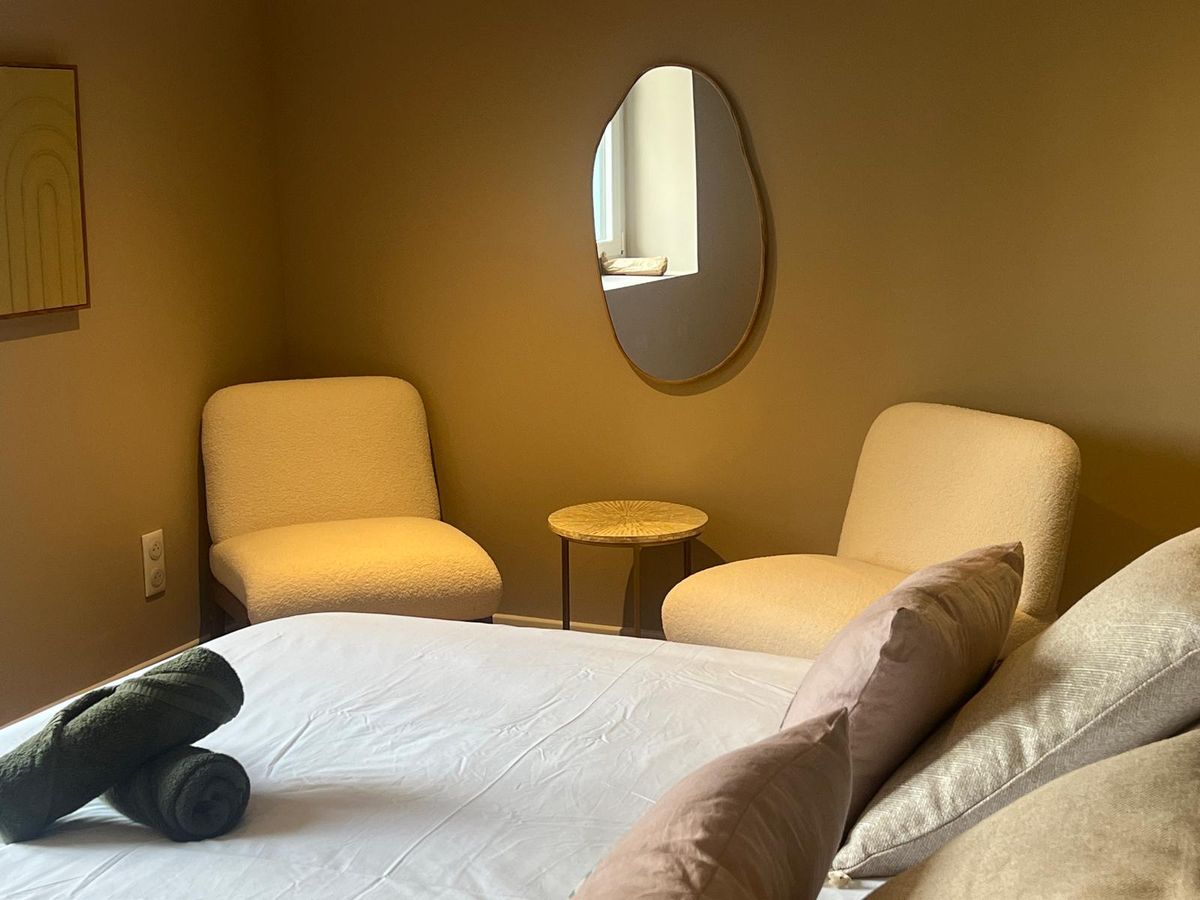 Bedroom — golden amber walls & boucle chairs