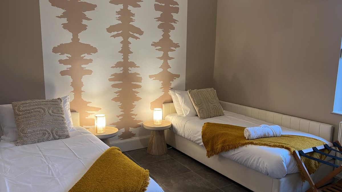 Second bedroom — twin beds & botanical wallpaper